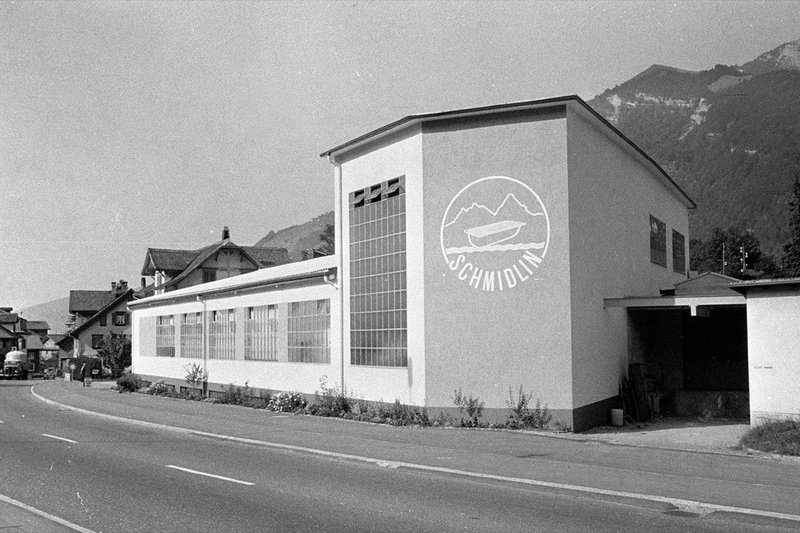 Historisches Schwarz-Weiss-Foto des Fabriukationsgebäudes in Oberarth mit Logo an der Fassade.