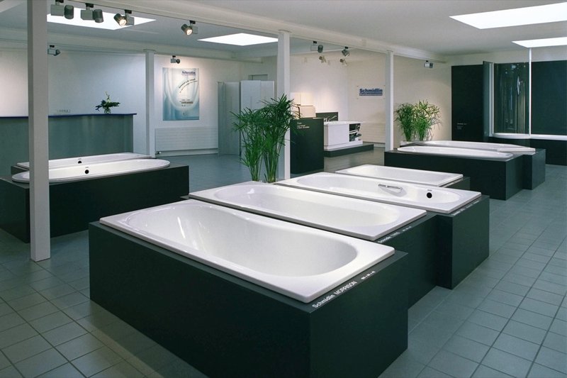 Ausstellungsraum der Wilhelm Schmidlin AG mit mehreren präsentierten Badewannen in moderner, heller Umgebung.