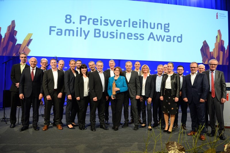 Gruppenfoto bei der 8. Preisverleihung des Family Business Award auf einer Bühne vor grossem Event-Hintergrund.