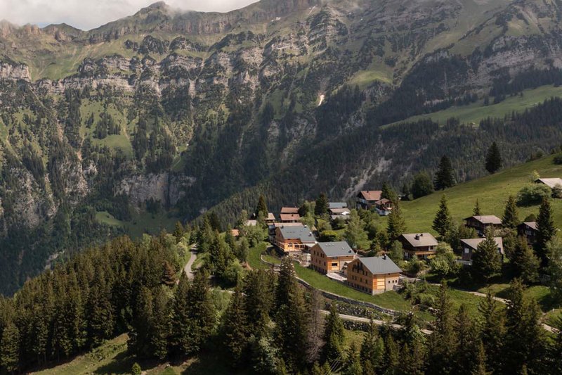 Berglodge 37 in alpiner Landschaft mit Chalets, Wiesen und Bergkulisse