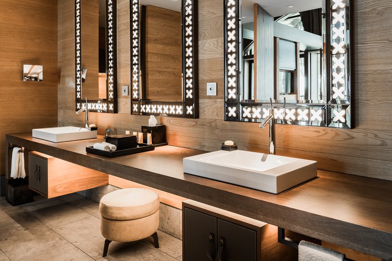 Modernes Badezimmer mit Doppelwaschtisch, Holzdesign und beleuchteten Spiegeln