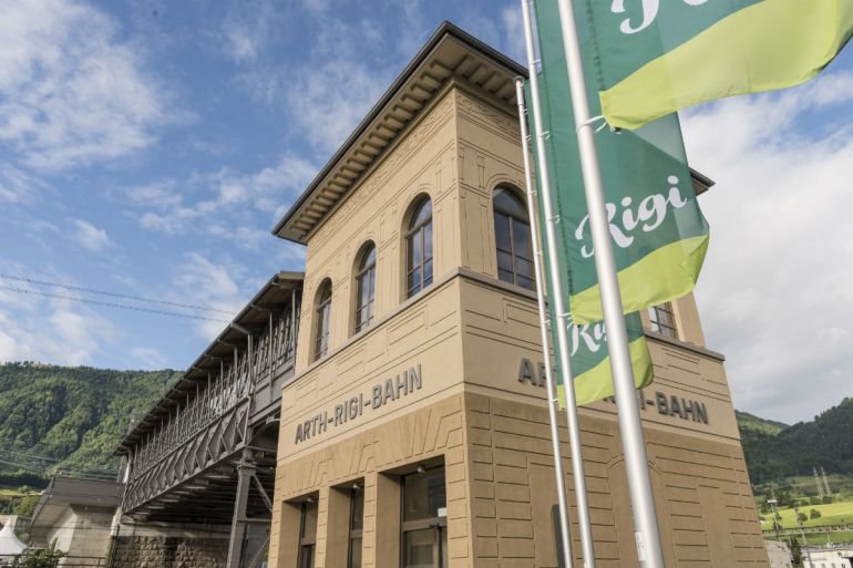 Talstation der Arth-Rigi-Bahn mit historischen Gebäuden und Fahnen in Rigi