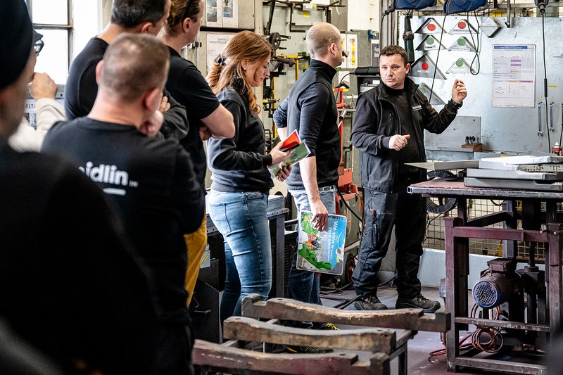 Mitarbeiter der Wilhelm Schmidlin AG präsentieren eine umgesetzte Verbesserung in der Produktion vor dem Team
