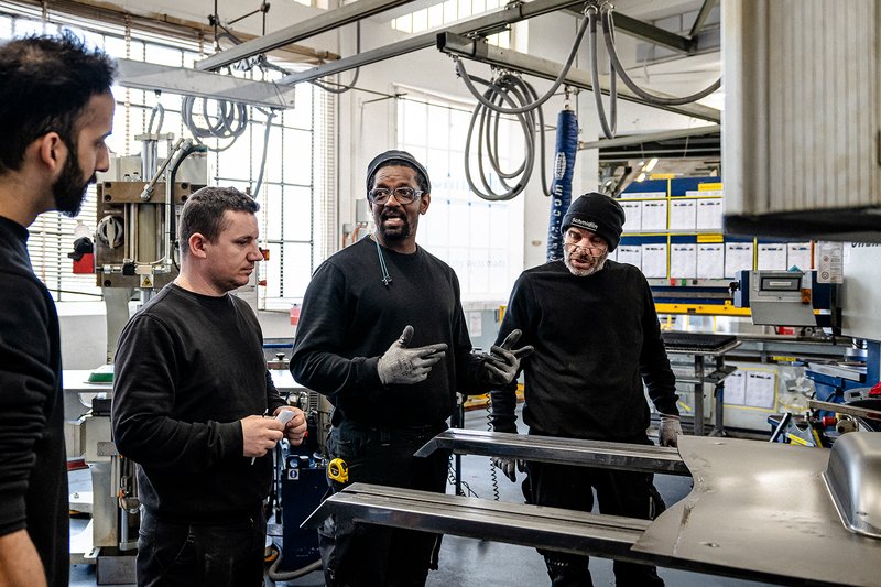 Mitarbeiter der Wilhelm Schmidlin AG besprechen gemeinsam Verbesserungen an einem Bauteil in der Produktion