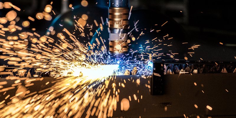 Laser-Schneidanlage in der Schmidlin Produktion mit Funkenflug beim Bearbeiten von Stahl