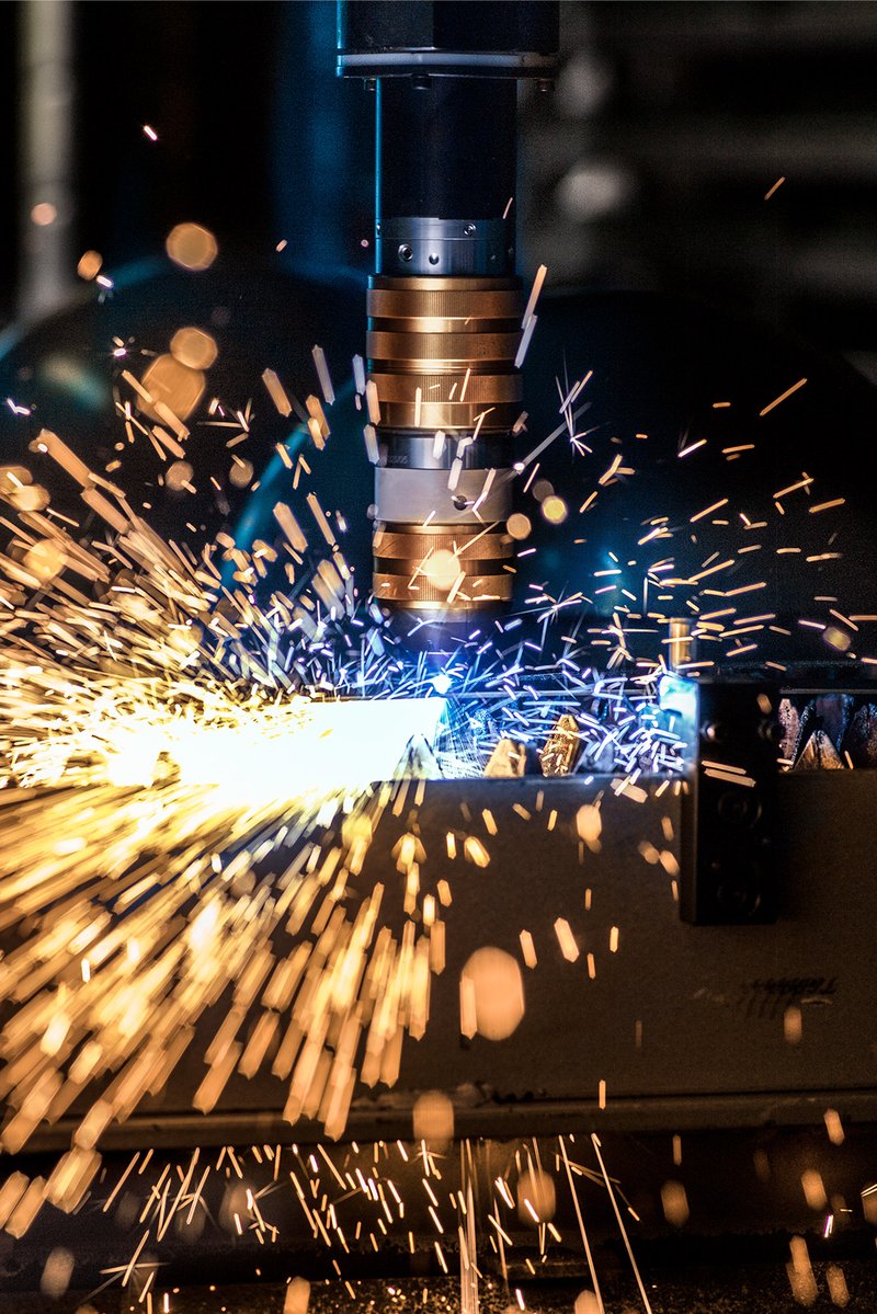 Laser-Schneidanlage in der Schmidlin Produktion mit Funkenflug beim Bearbeiten von Stahl