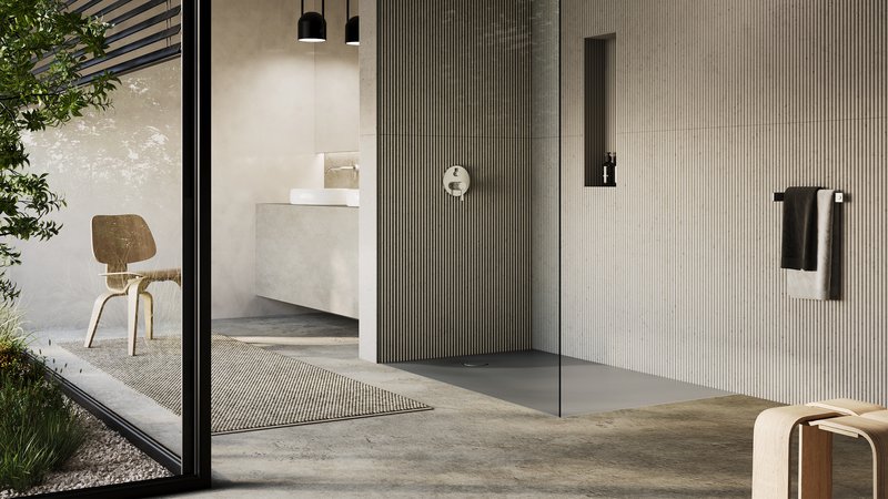 Architettura bagno moderna con superficie doccia a filo pavimento Schmidlin SWISS LINE, ampia parete doccia in vetro, superfici murali strutturate e luce naturale.