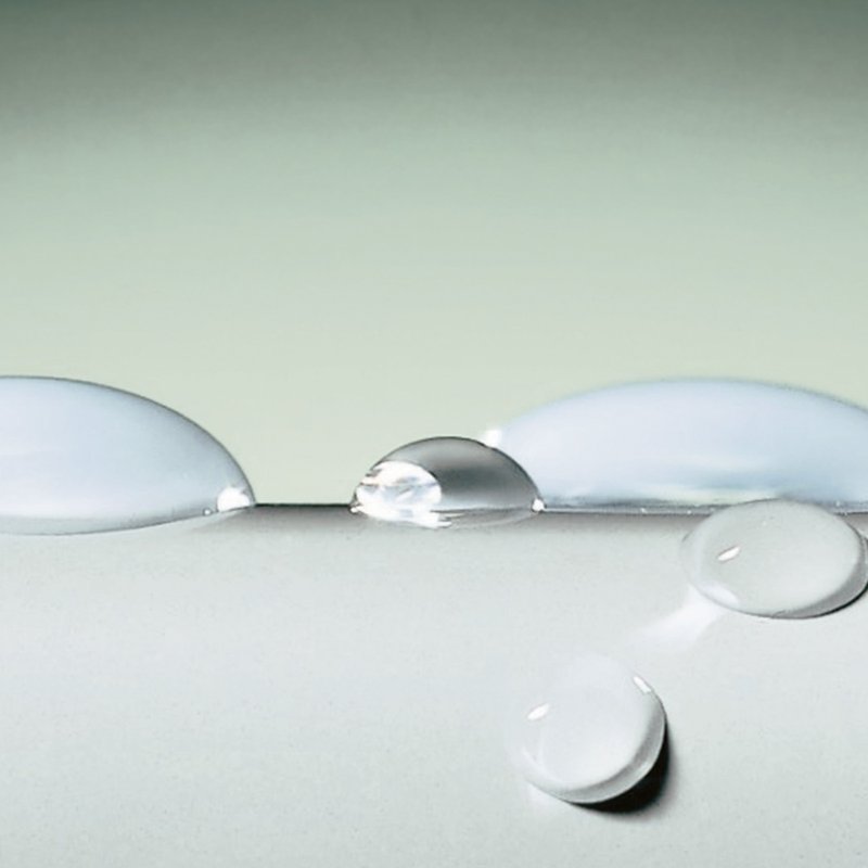 Wassertropfen perlen auf einer glatten Oberfläche ab – Darstellung der Beschichtung GLASUR PLUS.