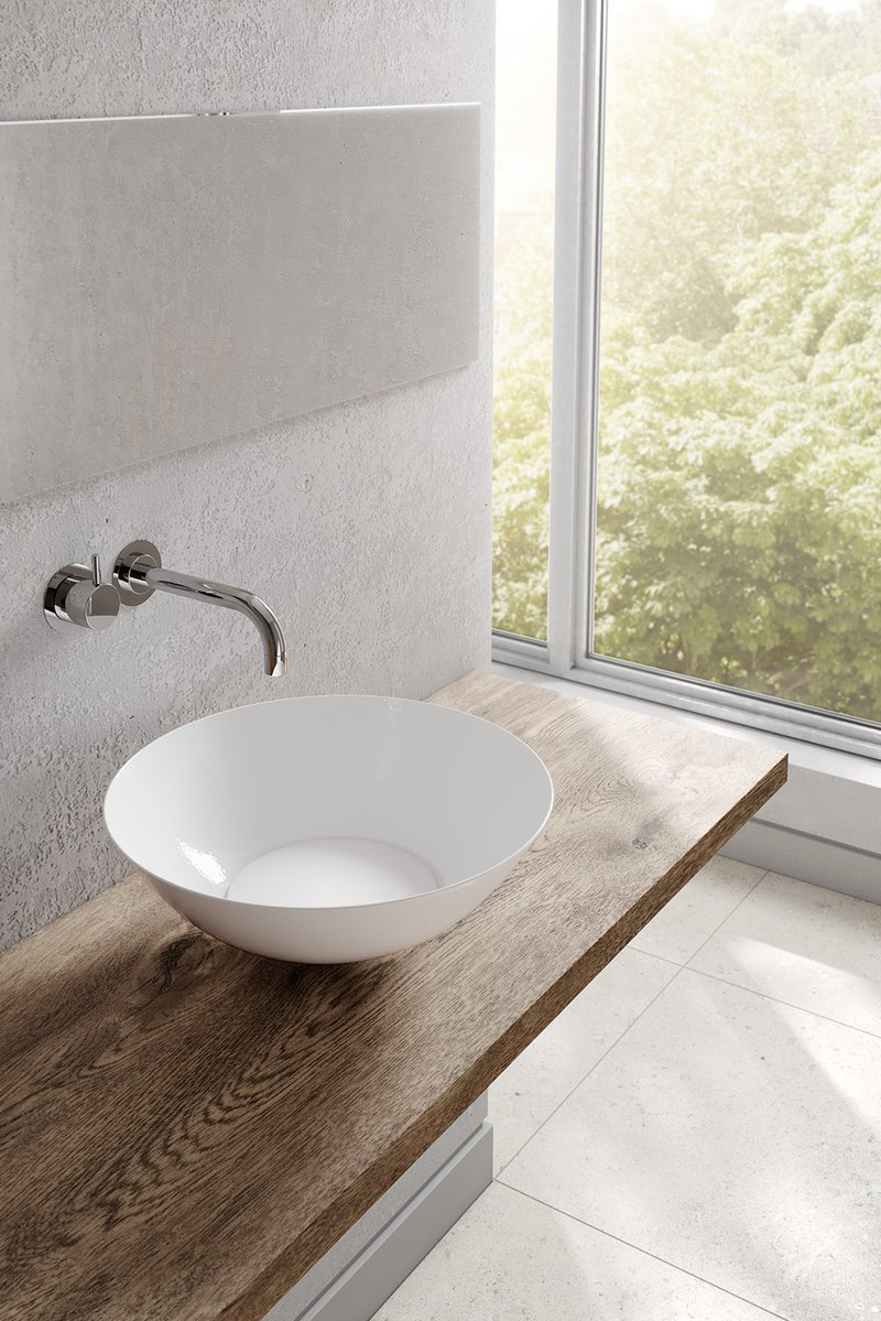 Detail eines modernen Badezimmers mit weissem Schalenbecken auf Holzplatte, Wandarmatur, Betonoptik-Wand und grossem Fenster mit Blick ins Grüne.