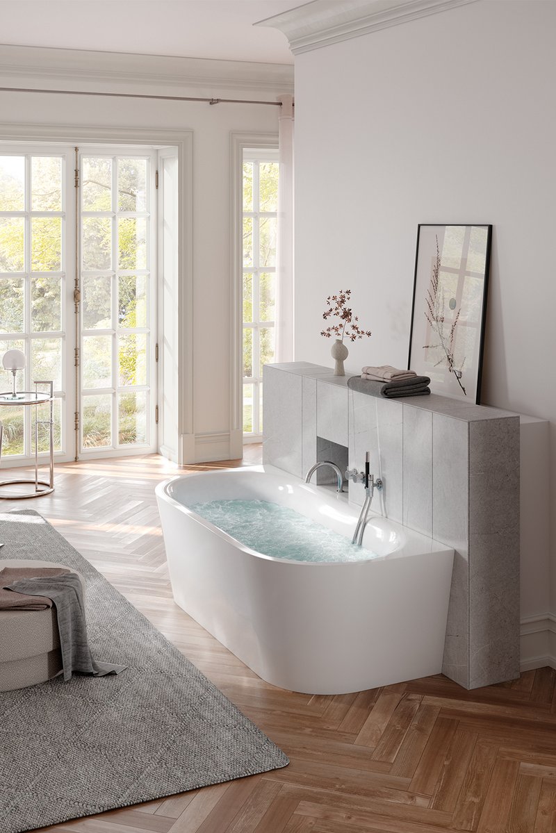 Stilvolles Badezimmer mit Schmidlin SELLA SHAPE FRONT Badewanne mit Whirlsystem, elegantem Parkettboden und hellem Tageslichtambiente.