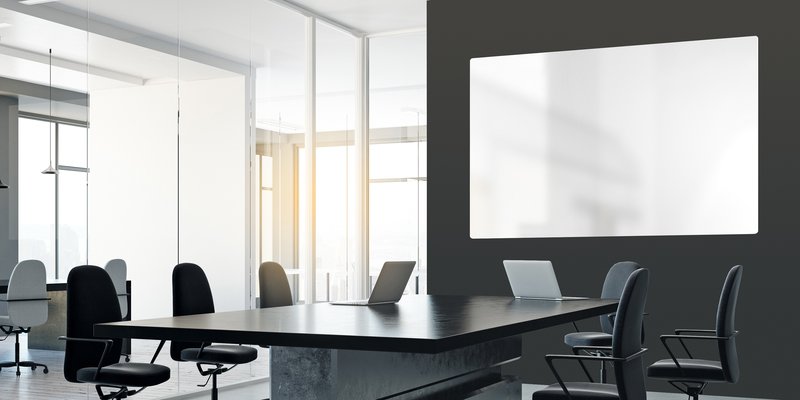 Modernes Besprechungszimmer mit Schmidlin Whiteboard an dunkler Wand.
