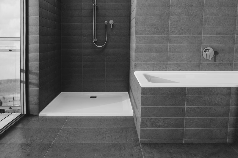 Schmidlin Stahl-Zargen bei Badewanne und Duschwanne in modern gefliestem Badezimmer.
