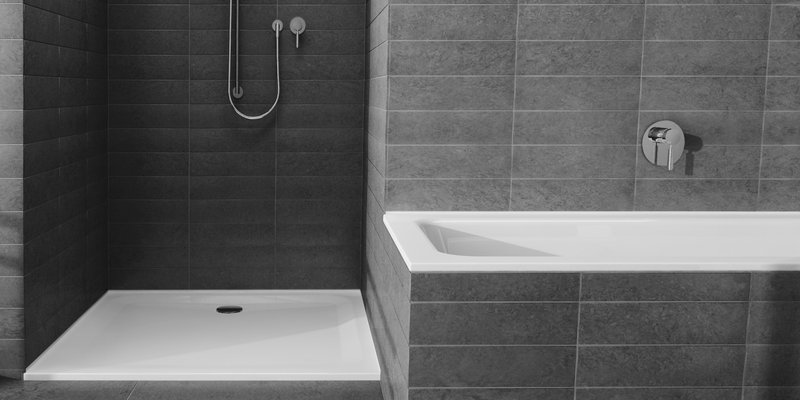 Schmidlin Stahl-Zargen bei Badewanne und Duschwanne in modern gefliestem Badezimmer.