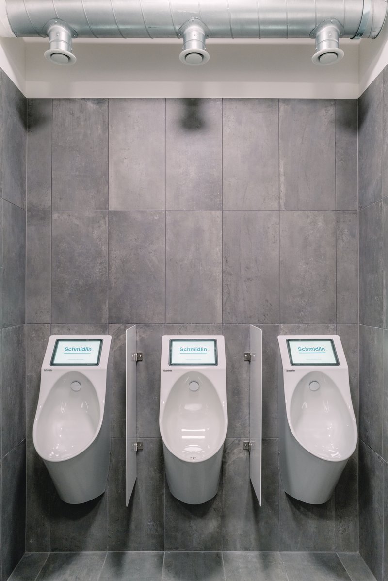 Moderne Urinale mit Trennwänden in einem minimalistischen Sanitärraum
