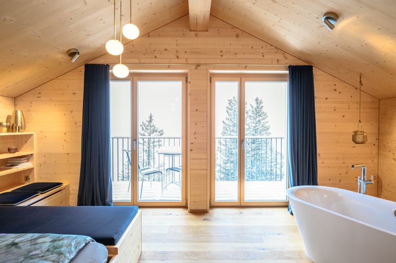 Gemütliches Chalet-Zimmer mit Holzinterieur, freistehender Badewanne und Balkon mit Bergblick