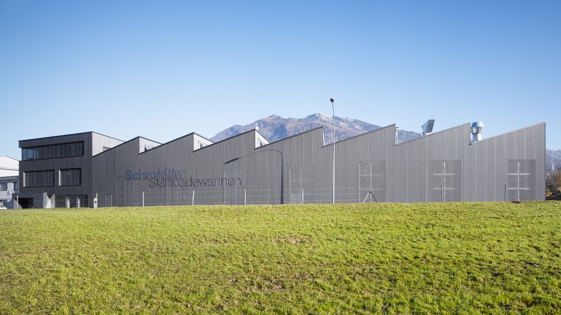 Schmidlin Produktionsgebäude in Oberarth vor Bergkulisse bei blauem Himmel